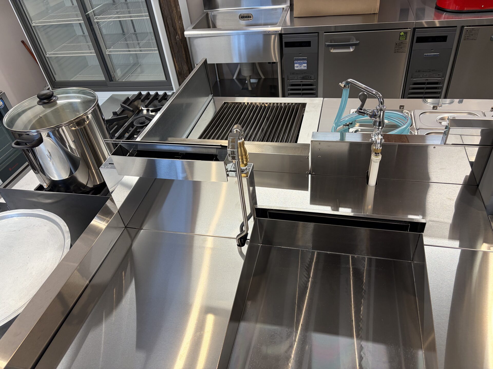 Stainless steel sink and washing workstation in the finished commercial kitchen