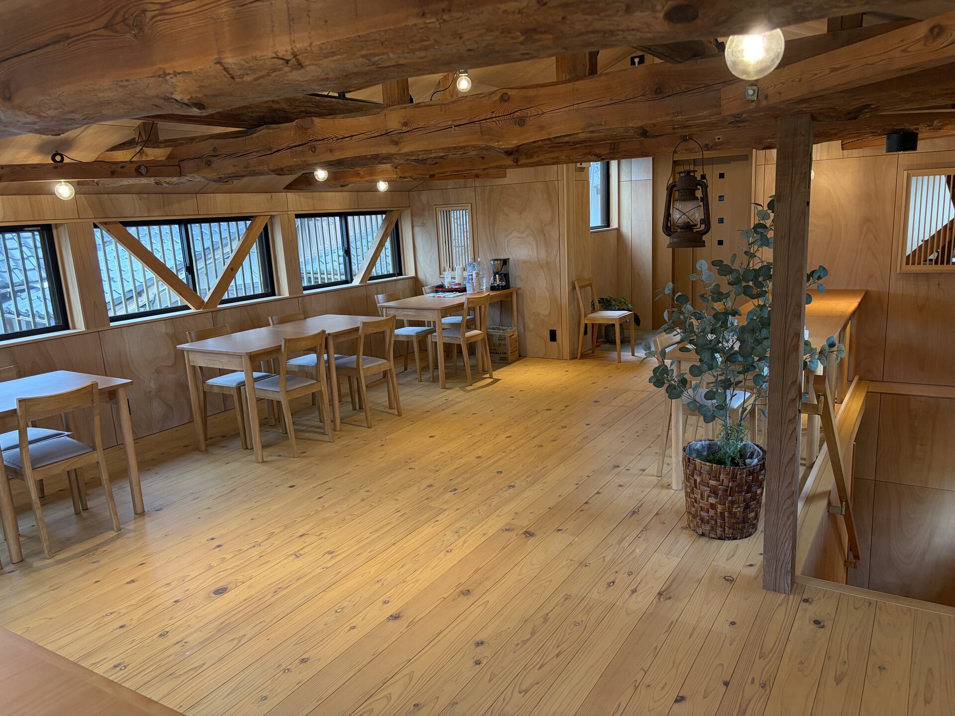 Finished dining room with exposed timber beams, wooden tables, and natural wood flooring